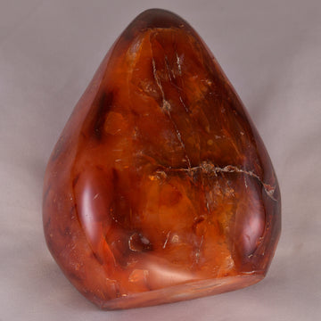 Deep orange-red Carnelian crystal, symbolizing motivation, courage, and energy.