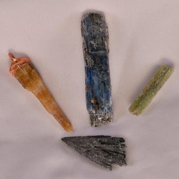 Array of Kyanite crystals in various colors, each reflecting its unique healing energy, from green's vitality to blue's clarity.