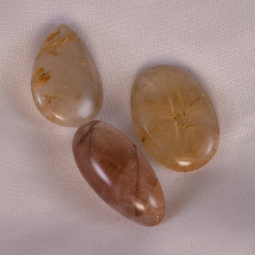 Assorted Rutile Quartz crystals, showcasing red, golden, white, and black strands.
