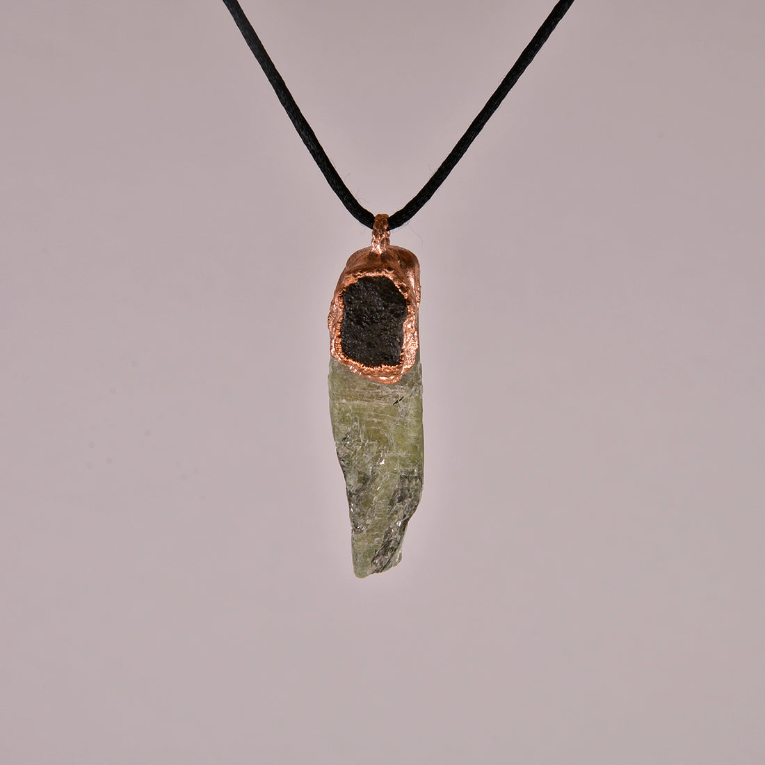 "Handcrafted copper electroformed pendant featuring Agni Manitite and Green Kyanite crystals, designed for esoteric and spiritual purposes. Unique, artisanal jewelry combining the grounding energy of Agni Manitite with the healing properties of Green Kyanite, perfect for those seeking balance and inner peace."