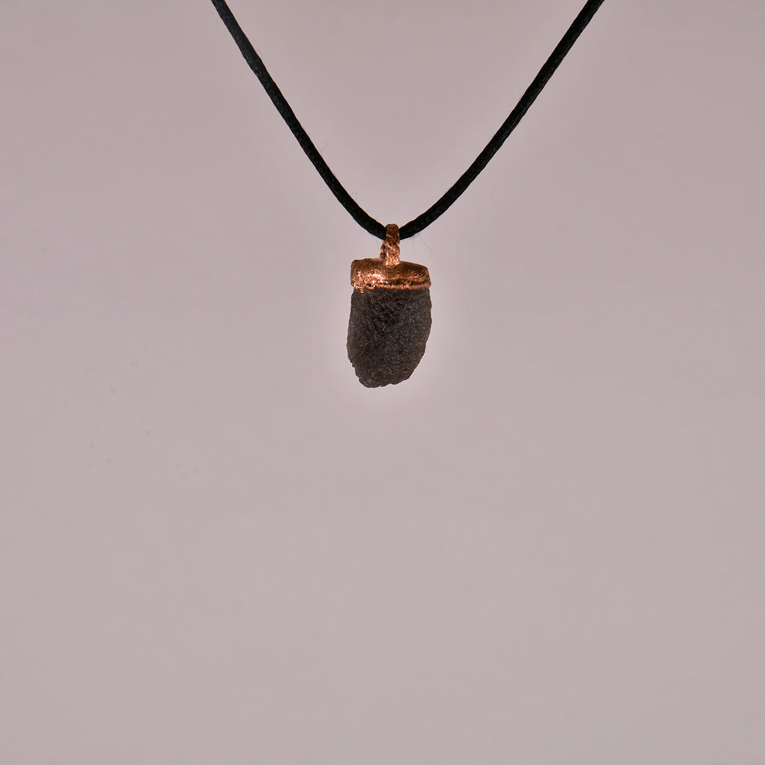 Agni Manitite Crystal Pendant, showcasing its unique texture and deep, dark hues, perfect for spiritual awakening and energetic alignment.