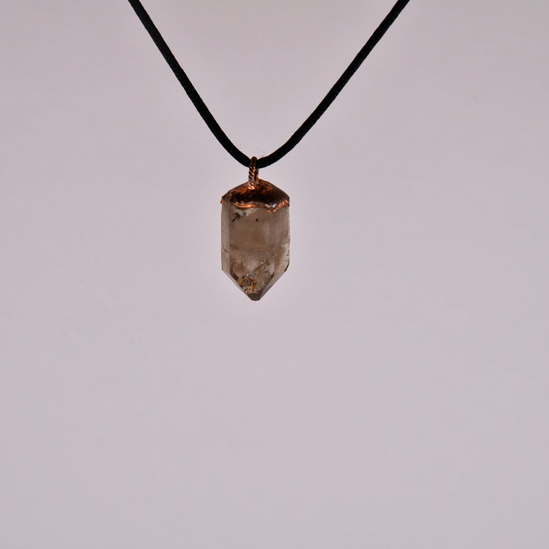 "Handcrafted copper electroformed pendant featuring a polished smoky quartz crystal, emitting grounding and protective energy. Unique esoteric jewelry piece for spiritual and healing purposes."