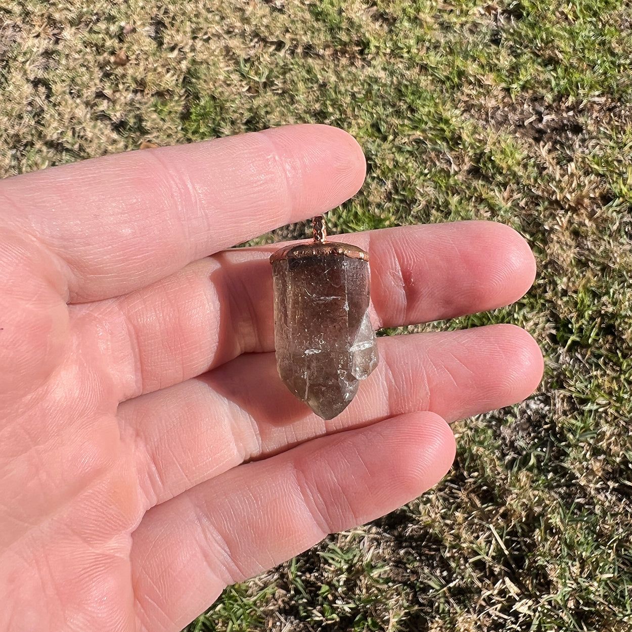 "Handcrafted copper electroformed pendant featuring a polished smoky quartz crystal, emitting grounding and protective energy. Unique esoteric jewelry piece for spiritual and healing purposes."