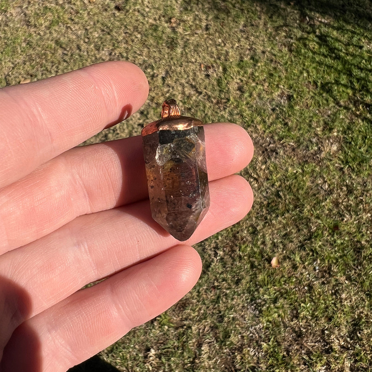 "Handcrafted copper electroformed pendant featuring a stunning Smoky Phantom Quartz crystal, perfect for adding a touch of esoteric elegance to your style."