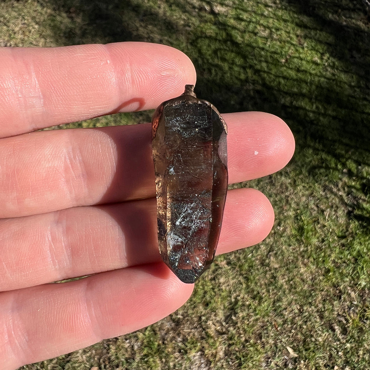 "Handcrafted copper electroformed pendant featuring a polished smoky quartz crystal, emitting grounding and protective energy. Unique esoteric jewelry piece for spiritual and healing purposes."