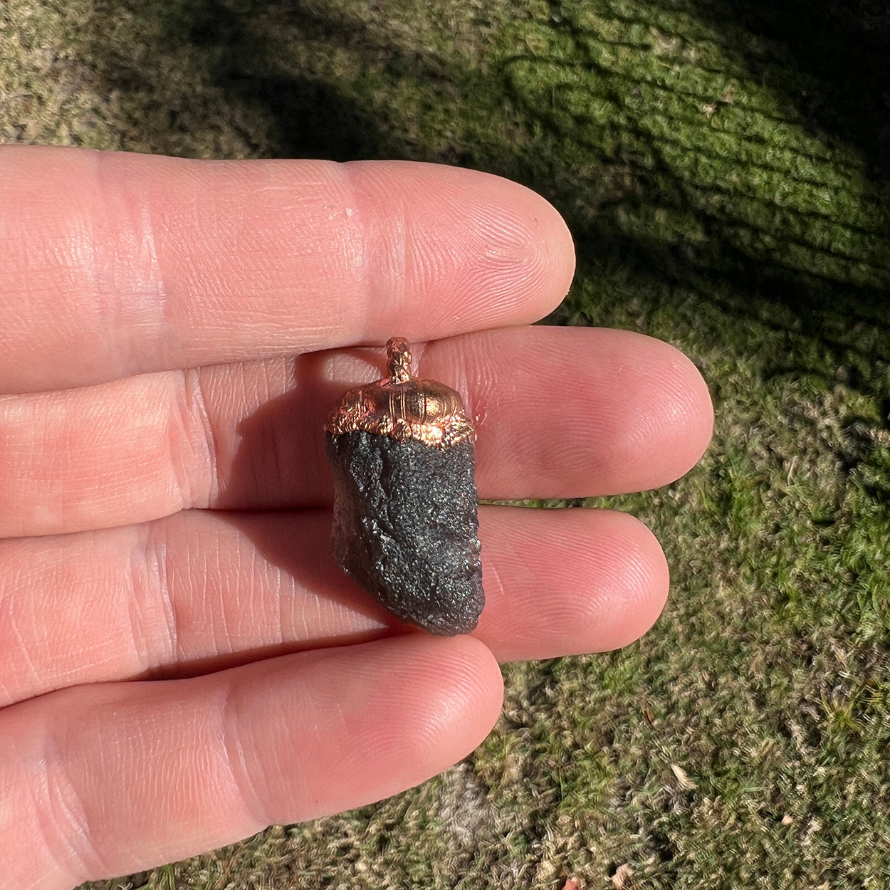 Agni Manitite Crystal Pendant, showcasing its unique texture and deep, dark hues, perfect for spiritual awakening and energetic alignment.