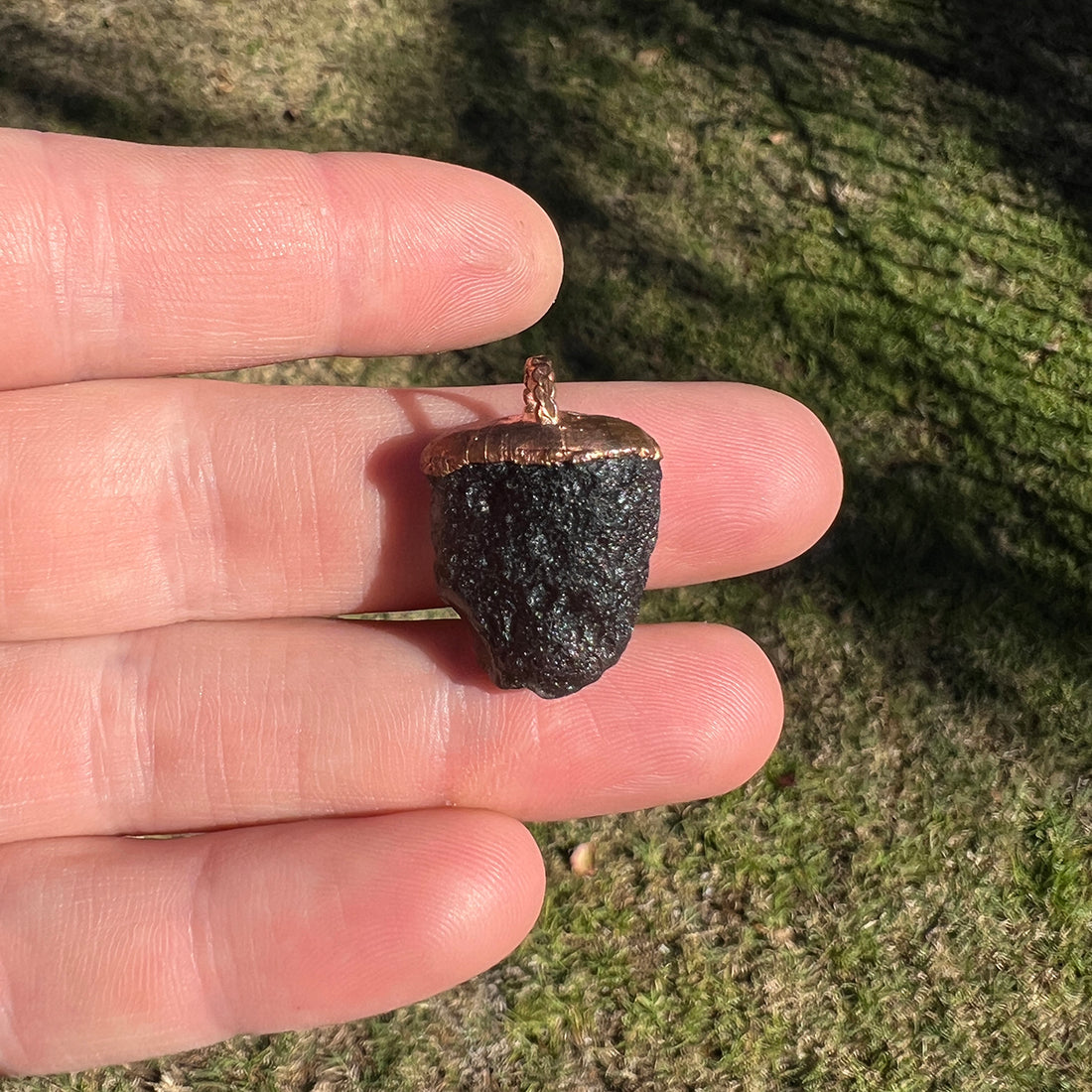 Agni Manitite Crystal Pendant, showcasing its unique texture and deep, dark hues, perfect for spiritual awakening and energetic alignment.